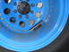 1992 Ford Bronco - Blue steel wheel with black center cap and tire, showing a mounted accessory.