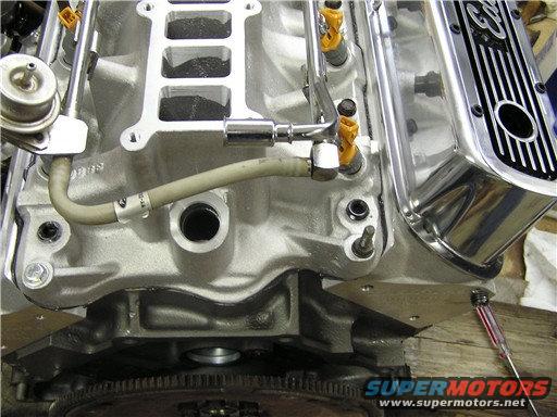 Close-up of a Ford V8 engine intake manifold with fuel injectors and a chrome valve cover