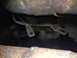 1973 Ford Torino - Undercarriage view showing rusty metal parts and fuel tank straps.