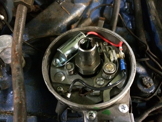 Close-up of a car's distributor cap interior with points and condenser visible