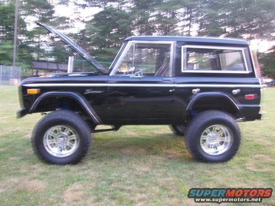 Black 1979 Ford Bronco parked on grass, hood open, side view