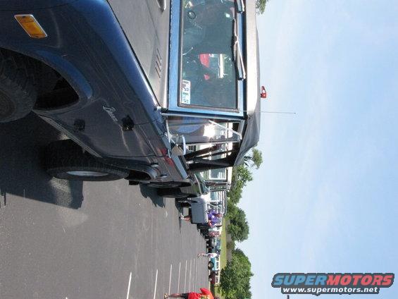 Dark blue Ford Bronco parked in a lot with other vehicles, side view