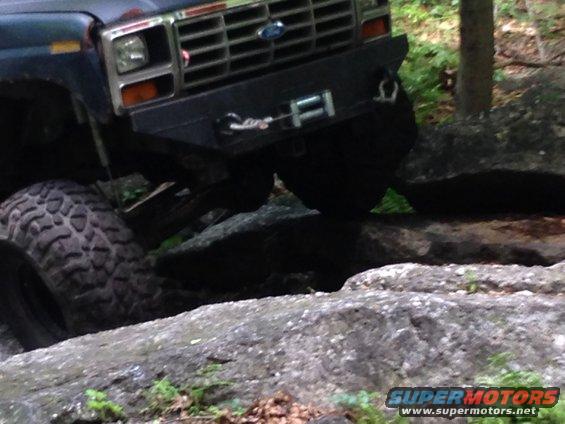 Ford Bronco with winch bumper navigating rocks on a trail