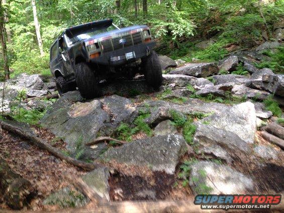 Black Ford Bronco navigating a rocky trail, front bumper modified