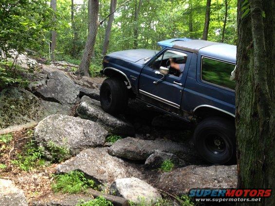 Blue 1987 Ford Bronco navigating rocky terrain