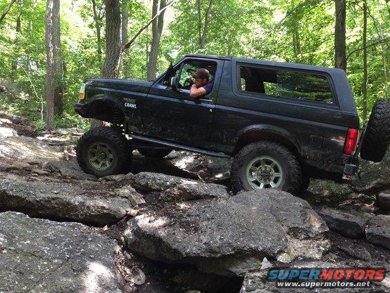 Black 1988 Ford Bronco climbing rocks