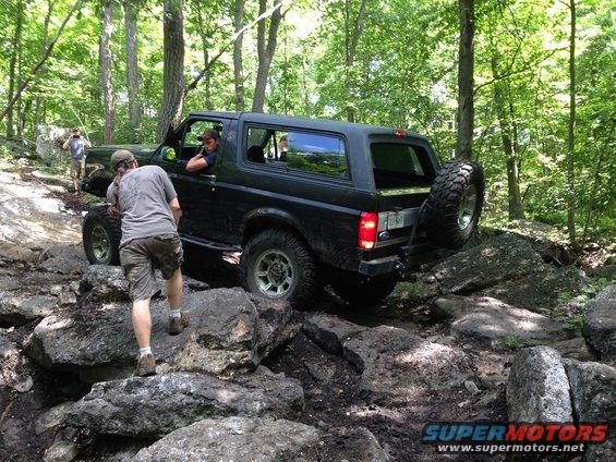 1988 Ford Bronco navigating a rocky trail with people nearby