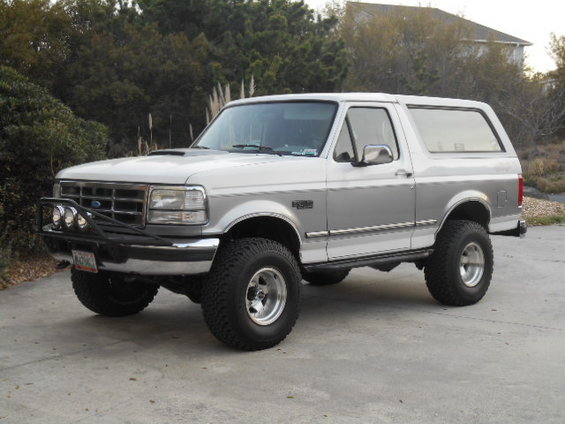 1994 Ford Bronco, 3/4 front view, white and silver with off-road tires and brush guard