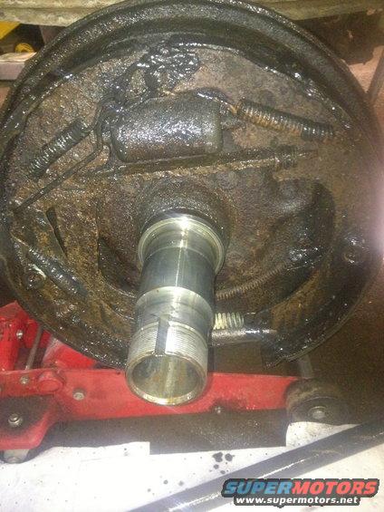 Drum brake assembly with visible springs and a metal shaft with threads