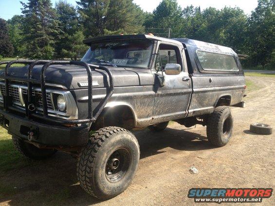 Black 1970 Ford F-250 with brush guard and camper shell