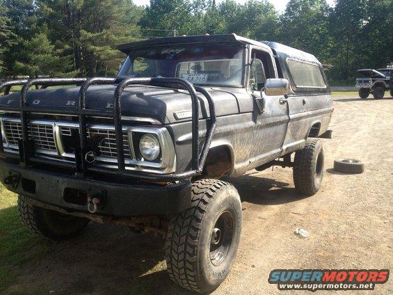 1970 Ford F-250 with brush guard and camper shell, parked outdoors