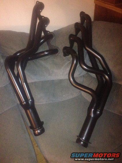 Pair of black exhaust headers on a couch