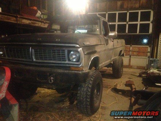 Gray 1970 Ford F-250 pickup truck with large tires, parked indoors