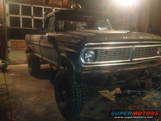 1970 Ford F-250 truck parked in a garage with the front grille and headlights visible