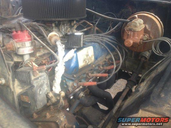 Engine bay with V8 engine, distributor, carburetor, and brake booster visible