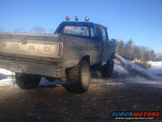 Rear view of a 1970 Ford F-250 with a blue roll bar and off-road tires