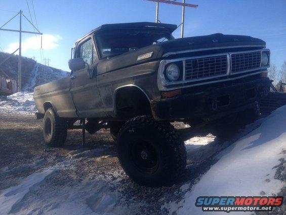 Black Ford pickup truck on snowy ground, front 3/4 view