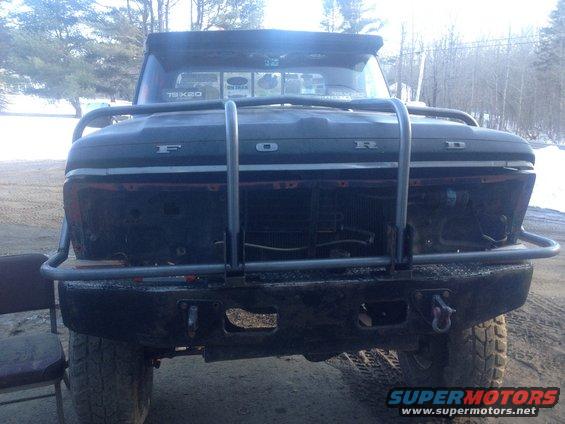 Black 1970 Ford F-250 front view with a large metal brush guard and aftermarket bumper
