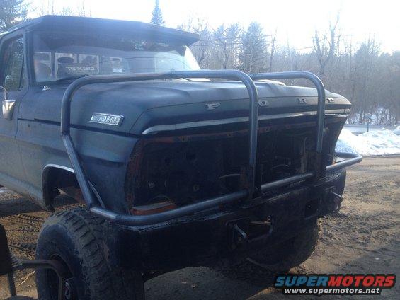 Front view of a dark blue 1970 Ford F-250 with a custom brush guard and missing grille