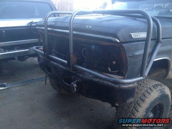 Black 1970 Ford F-250 front end with custom metal bumper and roll cage, missing headlights