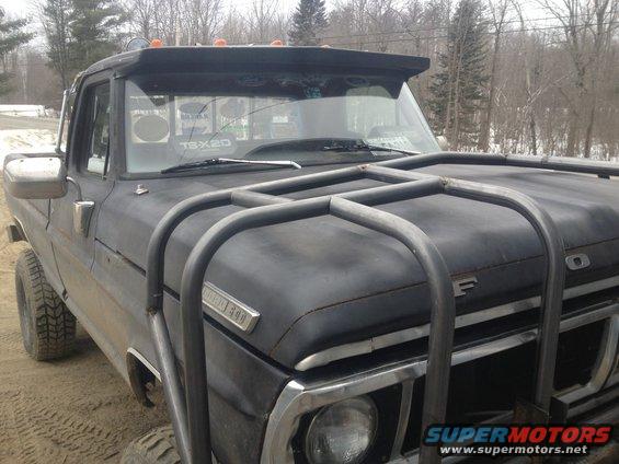 Black 1970 Ford F-250 with a custom front brush guard and visor