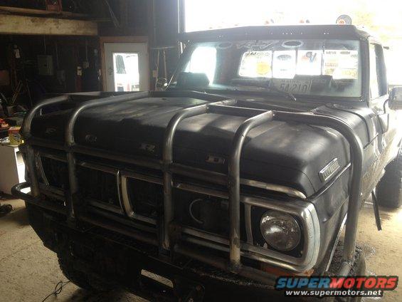 Front view of a black 1970 Ford F-250 with a large chrome bull bar. License plate visible