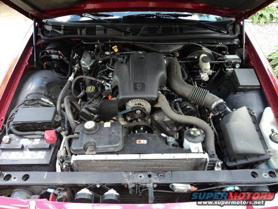 Engine bay of a 2004 Mercury Grand Marquis. Shows the V8 engine, battery, radiator, and air intake system