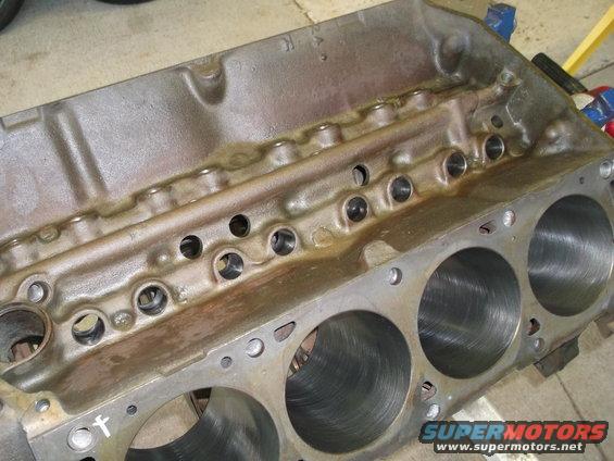 Engine block with visible cylinder bores and oil passages, metal casting