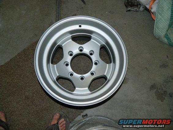 Silver aluminum wheel with five spokes and a multi-lug pattern