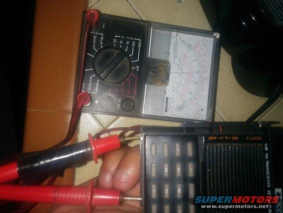 Analog multimeter connected to a VHF FM transceiver with probes