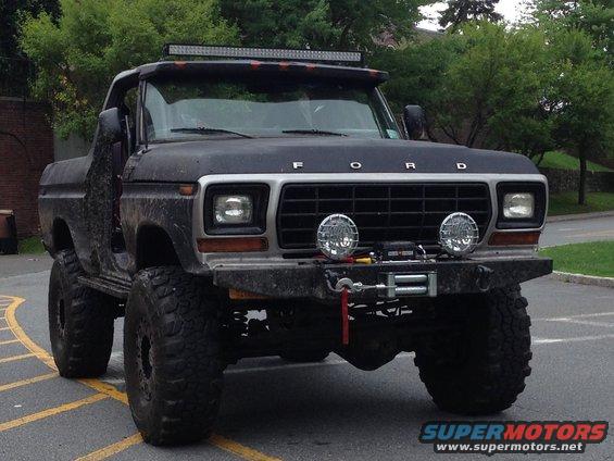 Black 1978 Ford Bronco with off-road modifications, including large tires, a winch, and a light bar