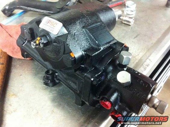 Black power steering gearbox with a PSC sticker and red capped fittings