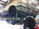 1988 Ford Bronco - Underside view of a lifted brown Ford Bronco undergoing maintenance.