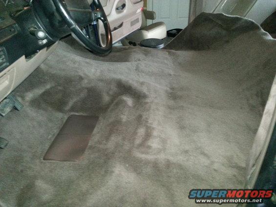 Interior view of vehicle carpet with steering wheel visible