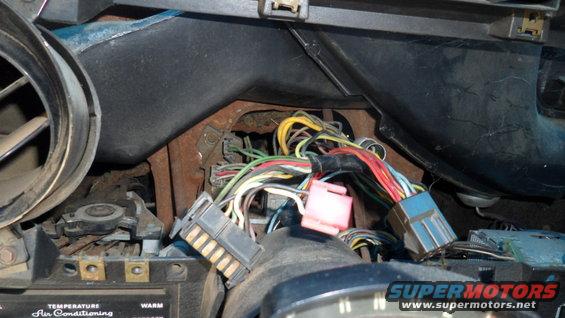 Vehicle dashboard wiring harness with blue, pink, and gray connectors, and numerous colored wires