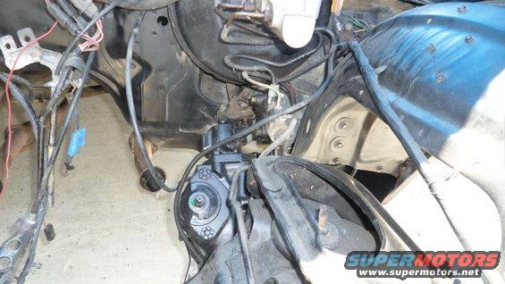 Close-up of vehicle engine bay with wiring and mechanical parts visible