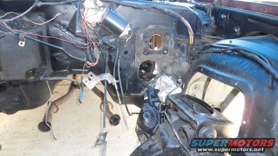 Engine bay with exposed wiring and parts. Maroon exterior visible