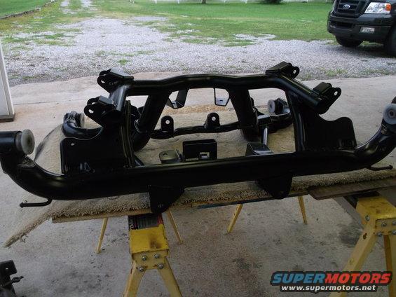 Black painted car suspension subframe assembly on sawhorses