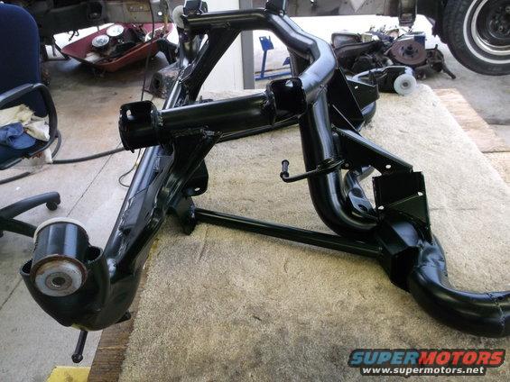 black painted car subframe assembly on a carpeted surface