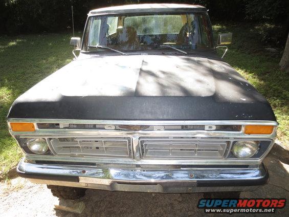 Front view of a 1973 Ford F-Series truck, hood is matte black, chrome bumper