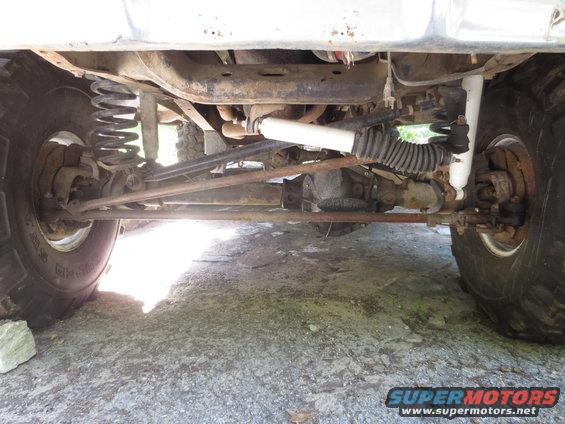 Underside view of a 4x4's front suspension, steering linkage, and differential