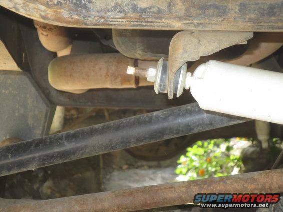 Undercarriage with exhaust pipe, shock absorber, and rusty metal components