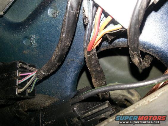 Close-up of a vehicle's wiring harness with multiple colored wires and connectors