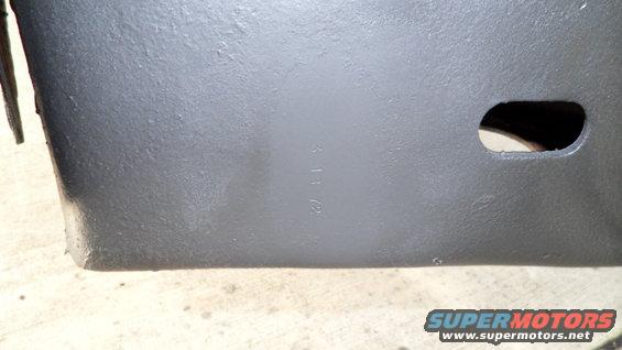 Dark gray painted metal part with stamped numbers '3 13 72'