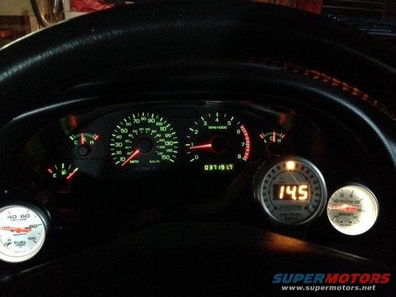 2002 Ford Mustang dashboard with speedometer, tachometer, fuel gauge, and aftermarket air/fuel ratio and boost gauges