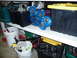 1993 Mazda MX-3 - Automotive suspension components are stored on a shelf with various containers and cleaning supplies.