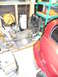 1993 Mazda MX-3 - Various automotive parts, including an engine and exhaust system, are stored in a garage with a red car visible.