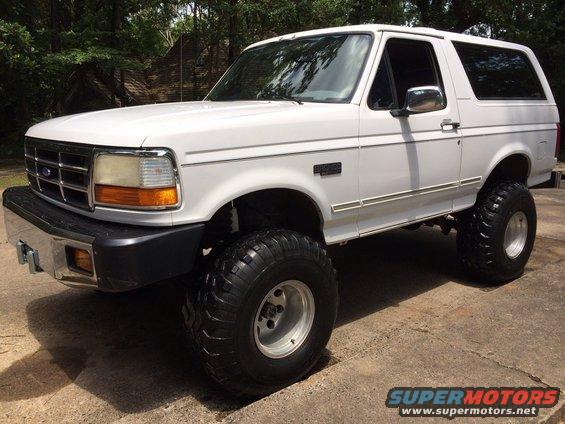 White 1994 Ford Bronco with large tires, 3/4 front view