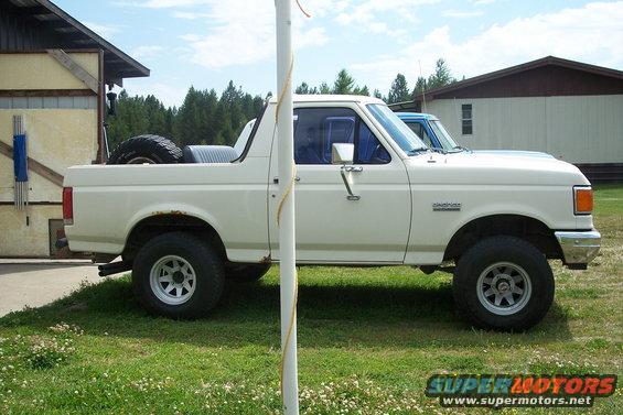 White 1990 Ford Bronco side view with spare tire in bed