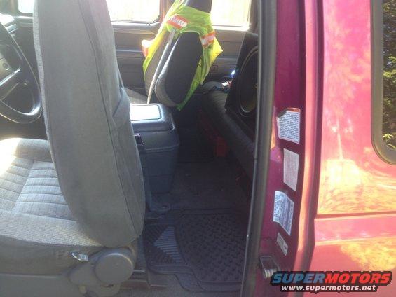 Interior of a 1992 Ford F-150 showing gray cloth seats, a black center console, and a door jamb sticker